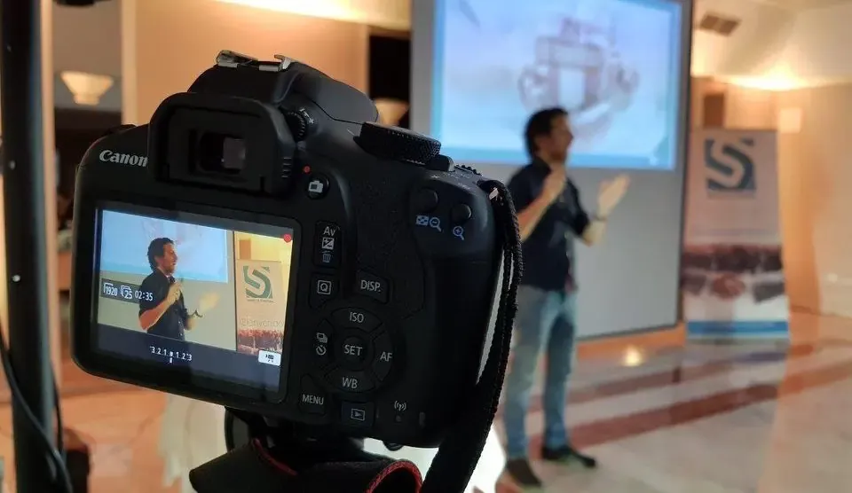 Dani Aragón durante su ponencia en Sinergia Córdoba, visto en la pantalla de una cámara