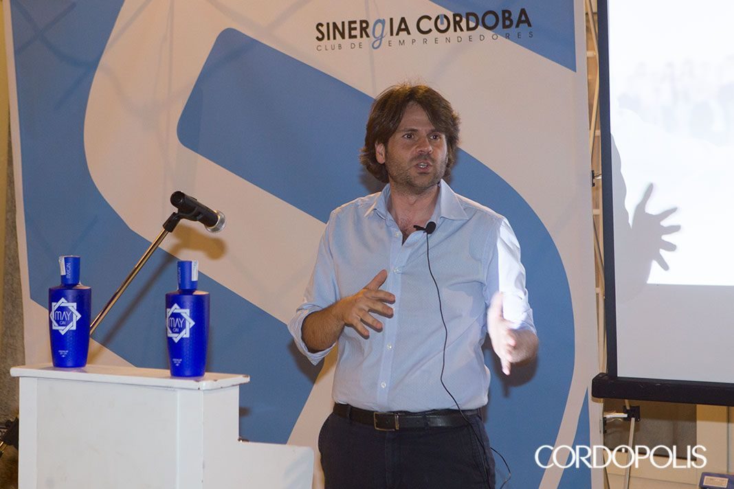 Un ponente se dirige a los asistentes junto al atril de Sinergia Córdoba en la Gala Primer Aniversario