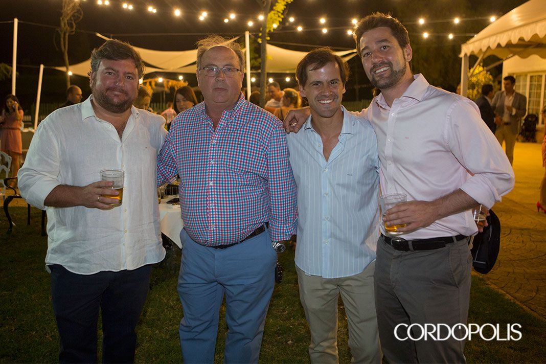 Cuatro socios de Sinergia Córdoba posan con una copa en el jardín durante la Gala Primer Aniversario