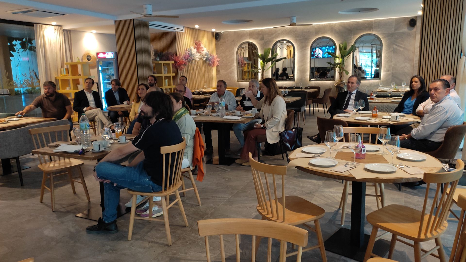 Empresarios de Sinergia Córdoba escuchan una presentación en un restaurante