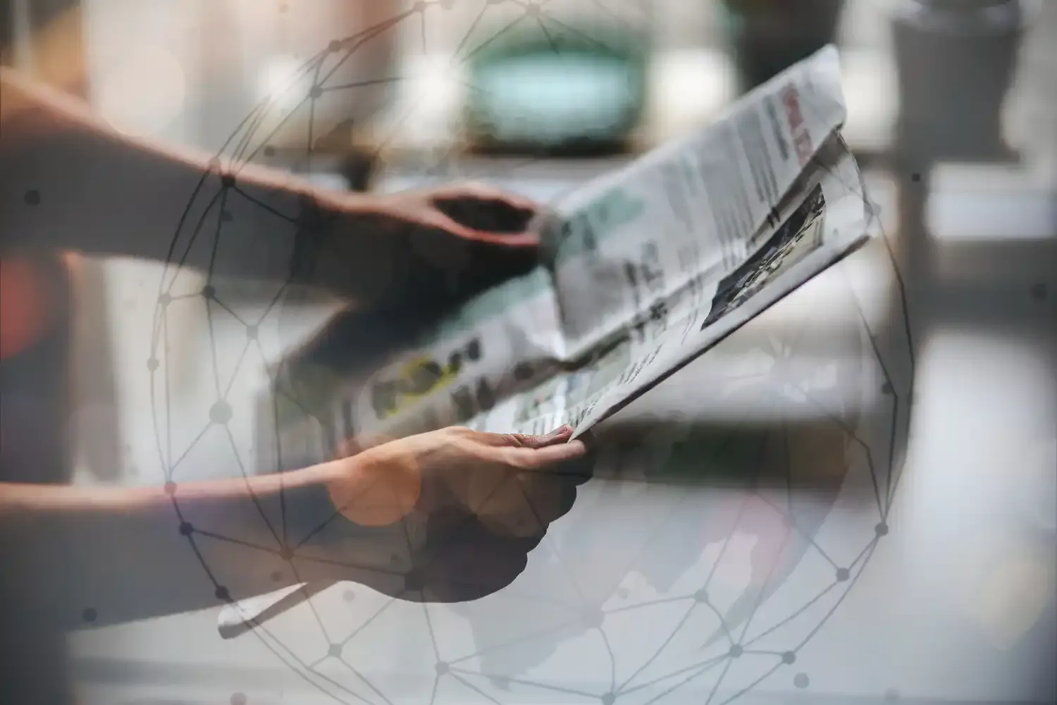 Manos sosteniendo un periódico abierto